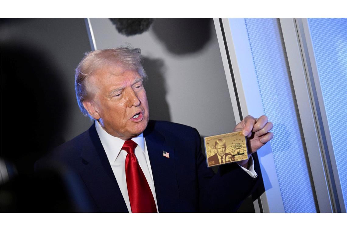 Bilder des Tages Präsident Donald Trump hält die goldene 5-Millionen-Dollar-Karte hoch, während er an Bord der Air Force One auf dem Weg nach Miami zu Reportern spricht.
