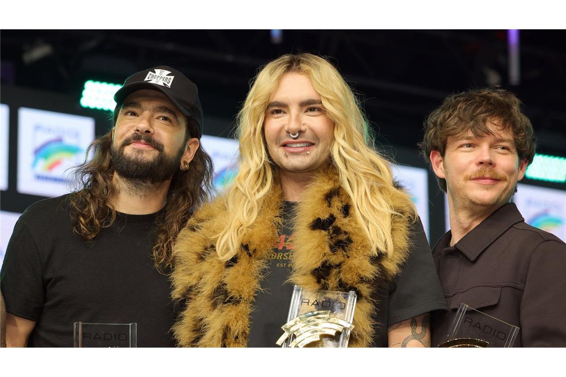 Preisträger Tom Kaulitz, Bill Kaulitz und Georg Listing von Tokio Hotel auf der Bühne der Preisverleihung (von links).