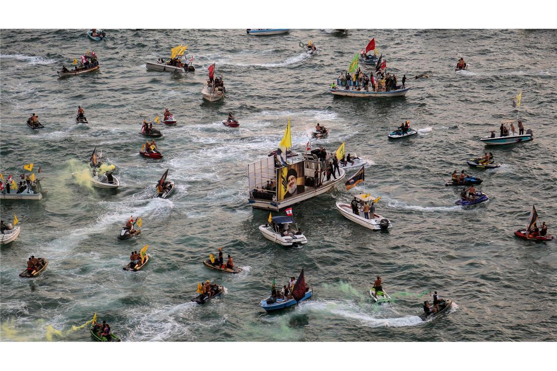 Pro-iranische Hisbollah-Anhänger auf kleinen Booten paradieren in der Nähe des libanesischen Taubenfelsens während einer Veranstaltung zum ersten Jahrestag der Tötung von Parteichef Hassan Nasrallah.