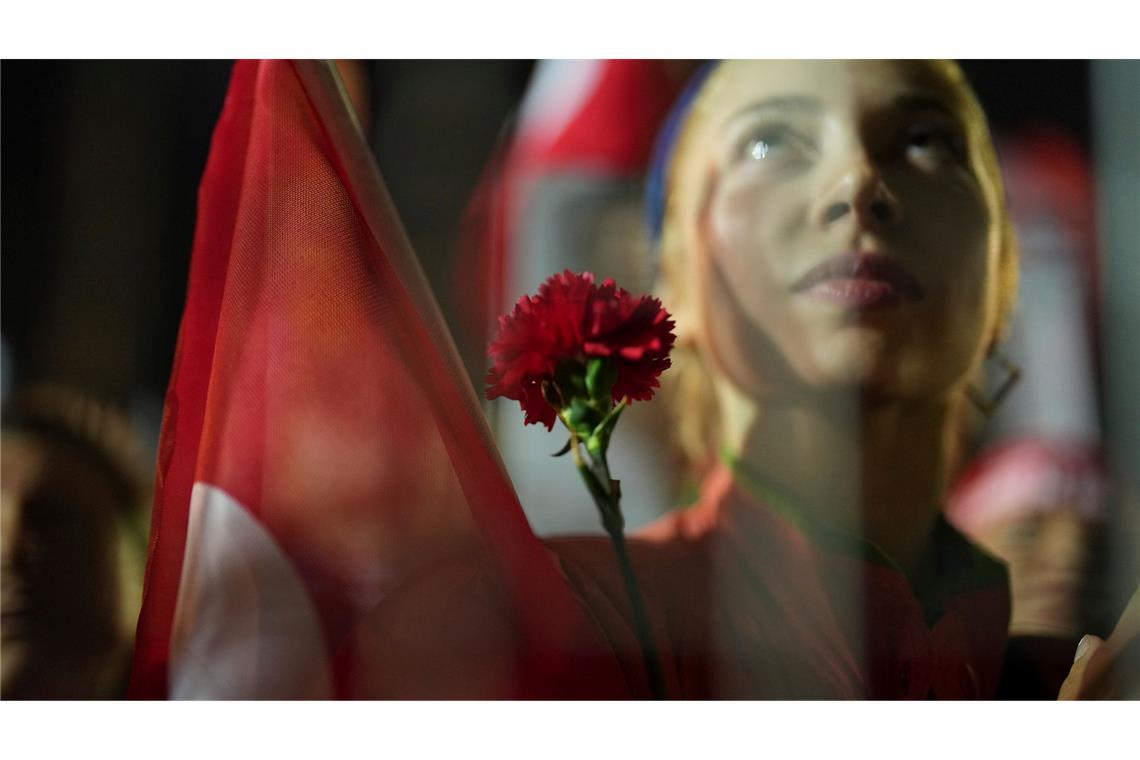 Bilder des Tages Proteste nach der Festnahme des Istanbuler Bürgermeisters - Eine Frau hält bei einer Demonstration in Istanbul eine Blume.