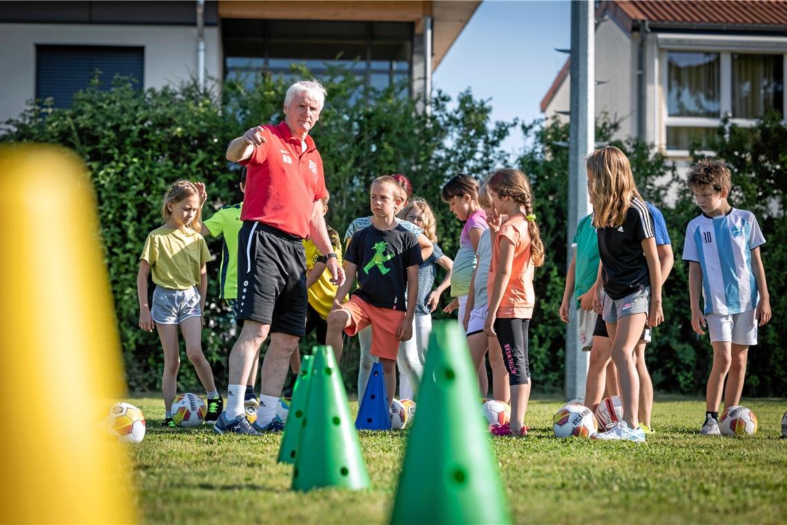 Kooperationen bieten für Schulen und Vereine einen enormen Mehrwert Rainer Dietrich erklärt den aufmerksamen Drittklässlern aus Großerlach, wie sie erst dribbeln und dann abziehen sollen. Foto: Alexander Becher