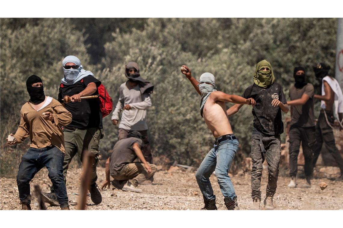 Rechtsgerichtete israelische Siedler werfen Steine auf palästinensische Dorfbewohner (Archivbild).