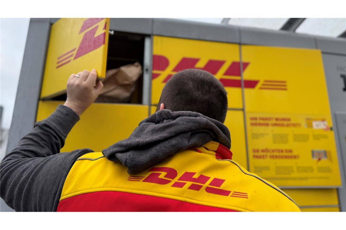 Rein in den Automaten, damit der Empfänger die Sendung später abholt: ein DHL-Paketbote bei der Abgabe von Sendungen an einer DHL-Packstation.