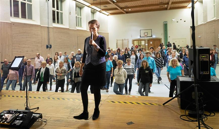 Renate Beger zeigt für alle gut sichtbar auf der Stadthallenbühne die Schrittfolgen. Das Erlernte ließ sich im Anschluss gleich austesten – beim Abend mit dem Countrygitarristen und -sänger Steven Taylor, der zum Tanz aufspielte. Foto: J. Fiedler