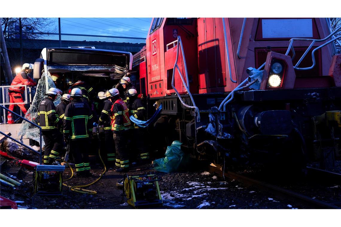 Retter kümmern sich um Verletzte nach Zusammenstoß von einem Linienbus und einer Lokomotive.