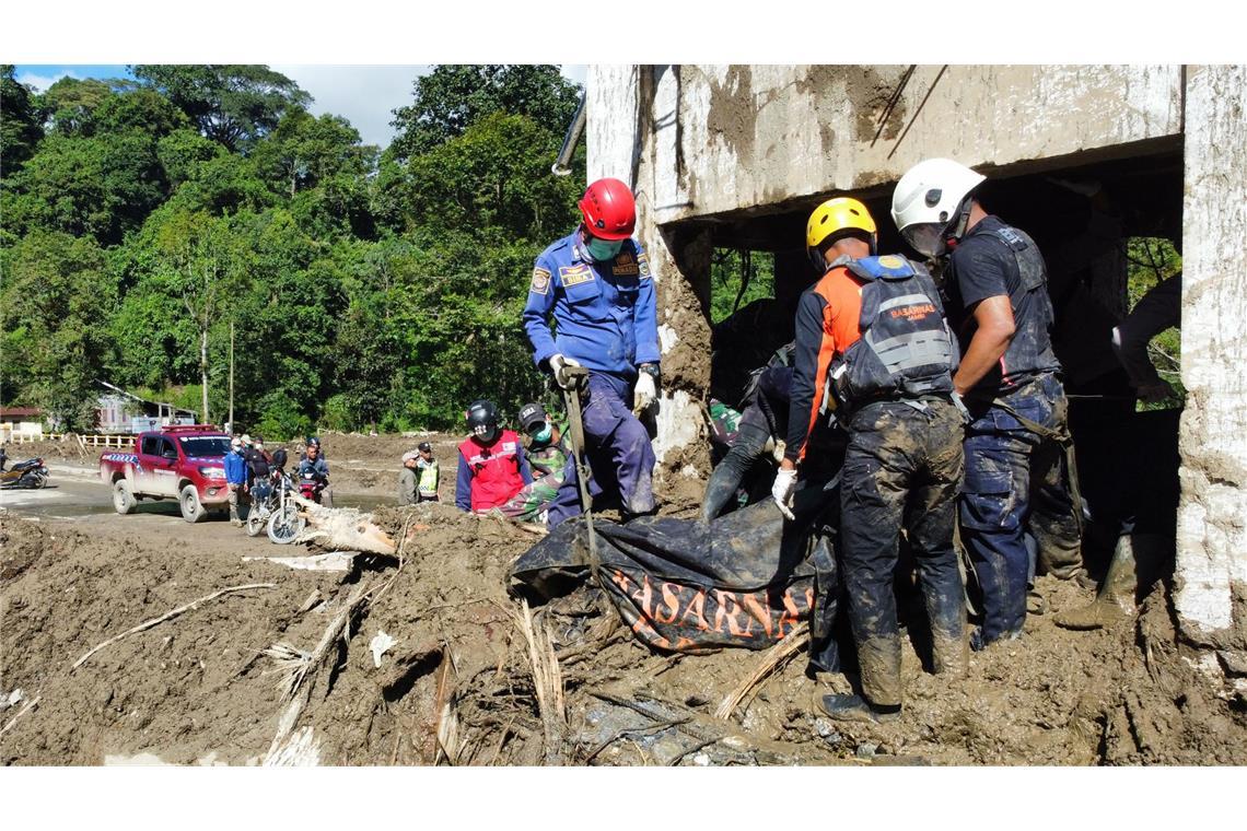 Rettungskräfte bergen die Leiche eines Überschwemmungsopfers in Westsumatra.