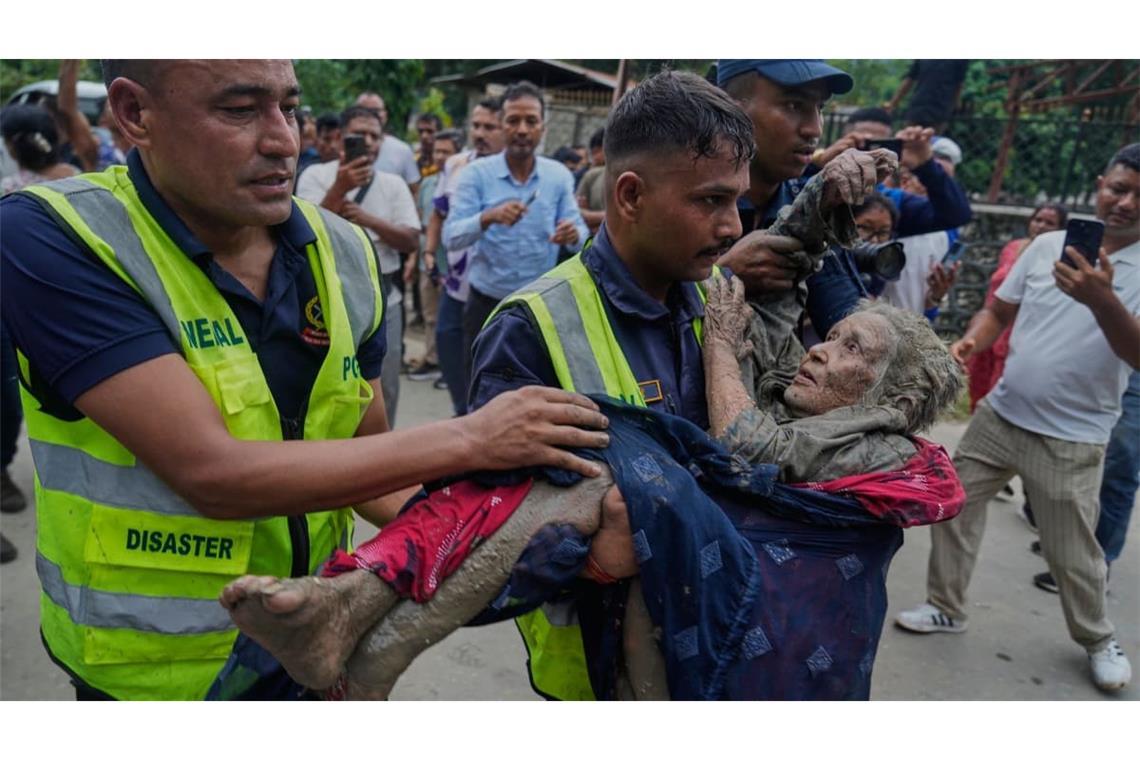Rettungskräfte bringen am Trishuli-Fluss im nepalesischen Distrikt Nuwakot ein Opfer einer Sturzflut in Sicherheit. Nach der heftigen Sturzflut in der Grenzregion zwischen China und Nepal gibt es mehrere Tote, nach Behördenangaben werden Hunderte Touristen vermisst.