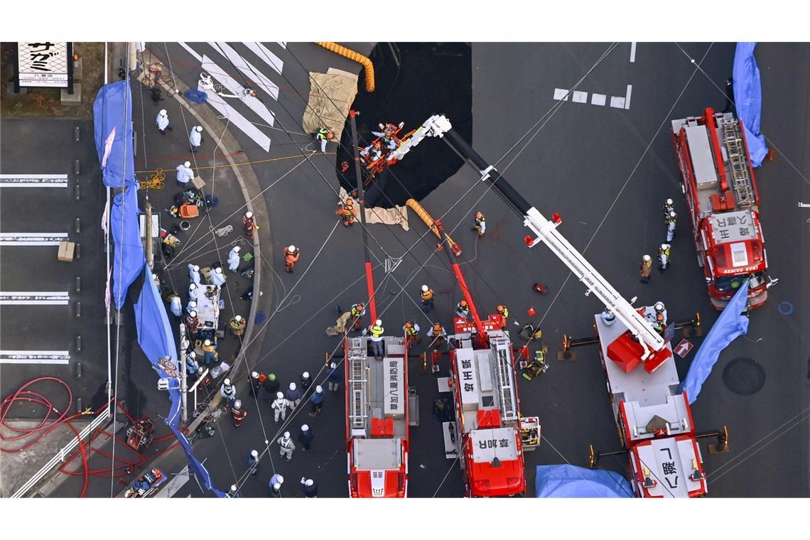 Erdloch verschluckt Lastwagen auf Kreuzung nahe Tokio Rettungskräfte holten einen Mann aus diesem Erdloch in Japan.