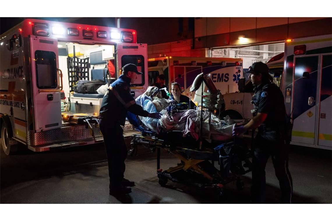 Rettungssanitäter laden nach einem Brand auf dem Stützpunkt der kanadischen Streitkräfte bei Wainwright, Alberta, eine verletzte Person im Wainwright Health Center in einen Krankenwagen.