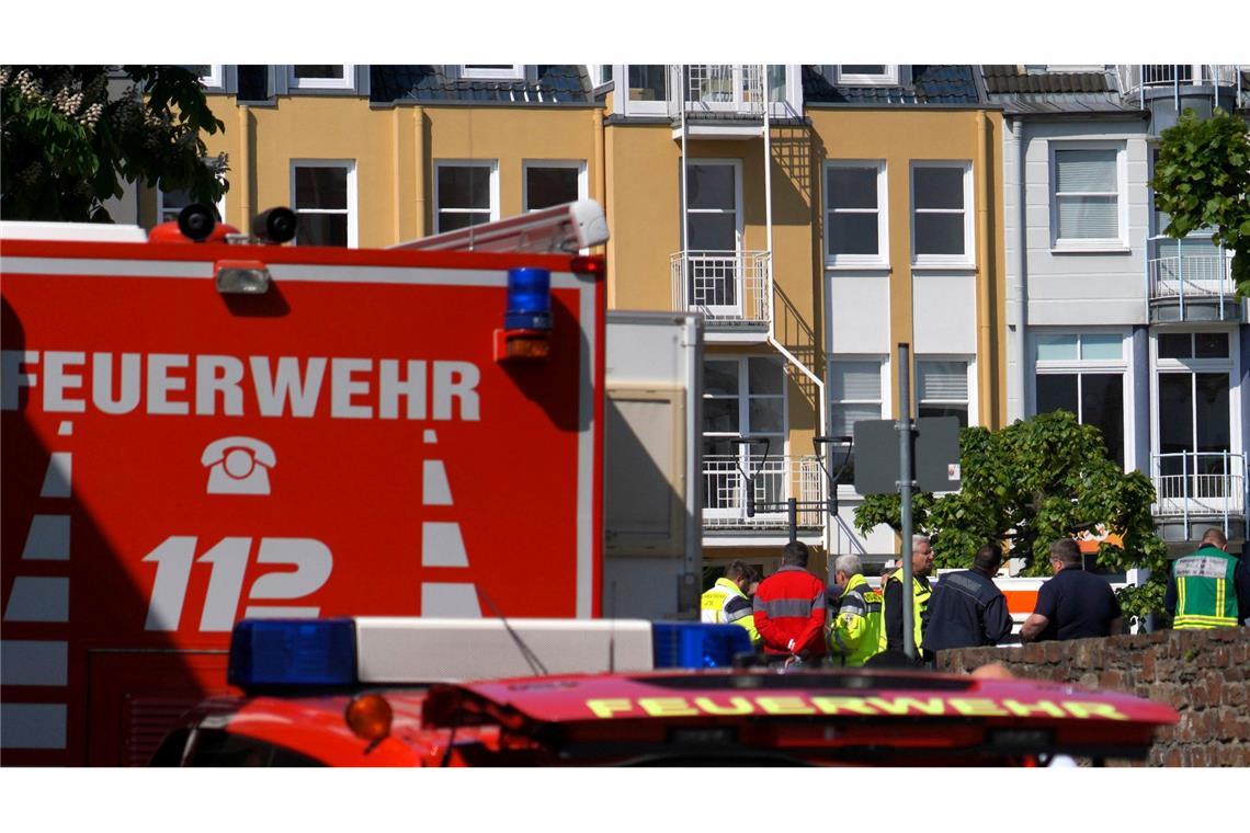 Rettungswagen, Polizisten und Polizeifahrzeuge stehen in der Nähe des Einsatzortes.