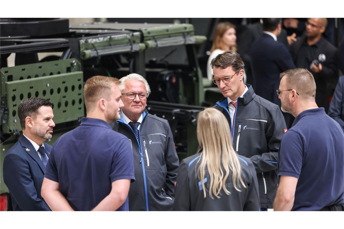 Rheinmetall startet als Zulieferer für Tarnkappenbomber Rheinmetall-Chef Armin Papperger (Dritter von links) und NRW-Ministerpräsident Hendrik Wüst (zweiter von rechts) bei einem Rundgang durch die F-35-Produktionsanlage.