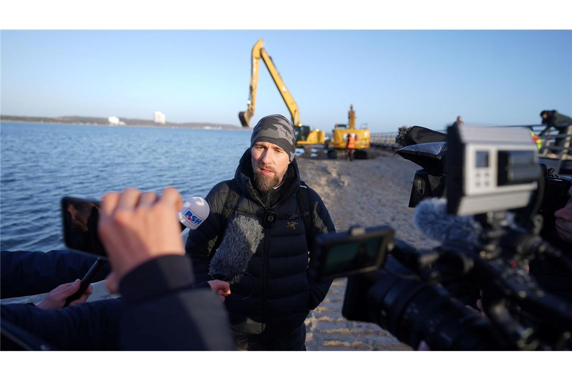Robert Marc Lehmann spricht mit den Medien am Strand, in dessen Nähe der gestrandete Buckelwal im Wasser gelegen hatte.