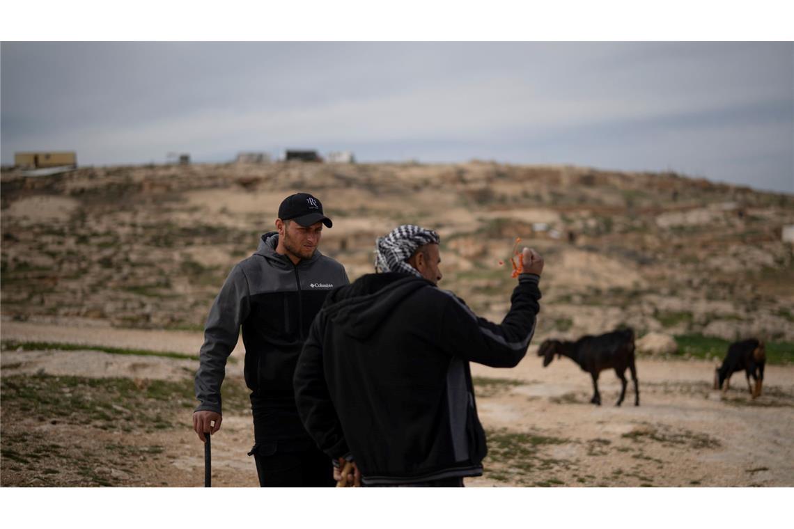 Bilder des Tages Salem Adra (l), Bruder des palästinensischen Aktivisten Basel Adra, der für "No Other Land" den Oscar für den besten Dokumentarfilm erhielt, unterhält sich mit einem palästinensischen Hirten in der Nähe eines israelischen Siedler-Außenpostens im Dorf Tuwani im Westjordanland.