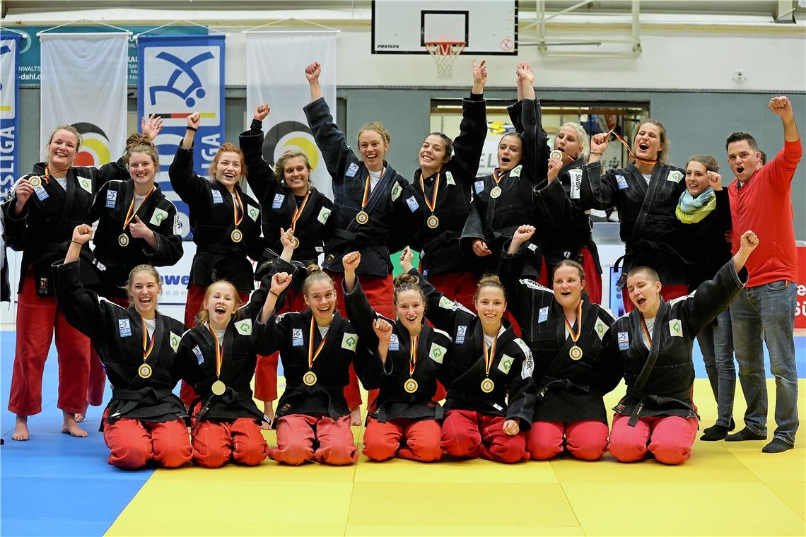 Backnanger Judofrauen holen dritten Titel Sanne van Dijke, Malin Fischer, Lubjana Piovesana, Julia Mollet, Sarah Mäkelburg, Alina Böhm, Raffaela Igl, Anamari Velensek, Anna-Maria Wagner, Physiotherapeutin Stephanie Holderle, Trainer Jens Holderle (hinten von links), Sarah Mehlau, Nikita Krieger, Viktoria Folger, Chiara Serra, Amelie Stoll, Tanja Hehr, Jasmin Delorme (vorne) jubeln über Gold. Foto: F. Hoffmann