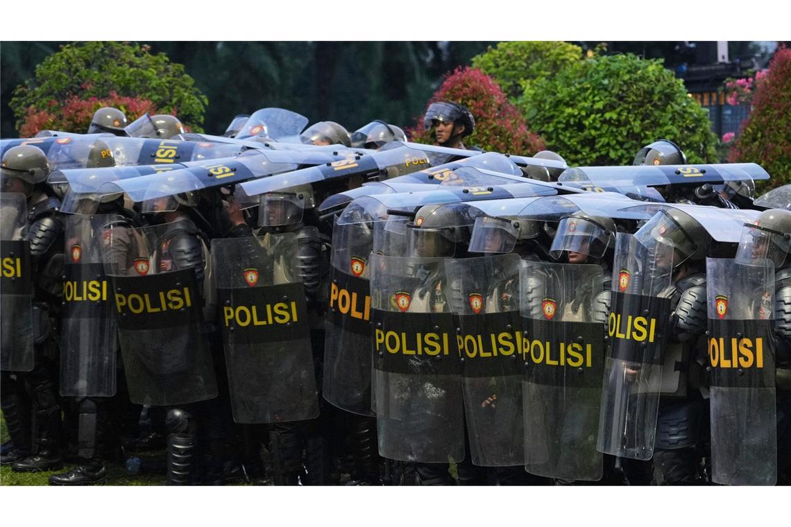 Bilder des Tages Schildwall: Bereitschaftspolizisten in Indonesien gehen während einer Kundgebung gegen die Verabschiedung einer umstrittenen Änderung des Militärgesetzes in Stellung.