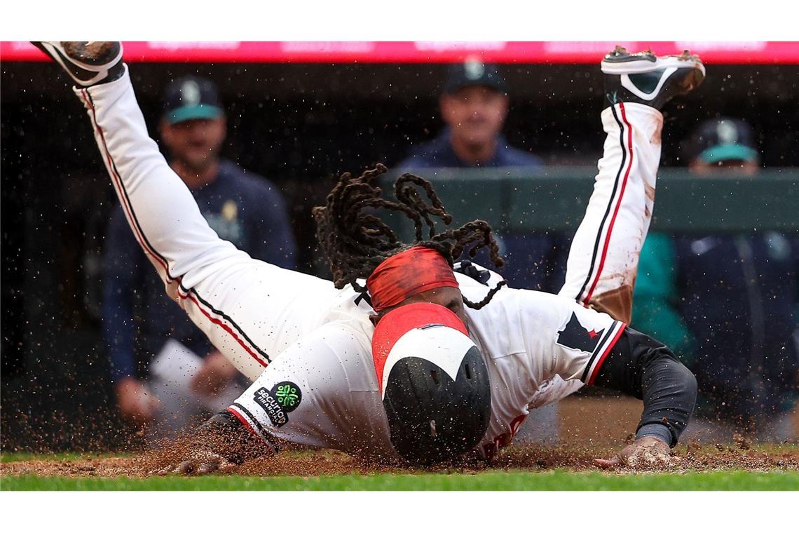 Schlagmann der Minnesota Twins, Josh Bell, rutscht sicher auf die Home Plate.
