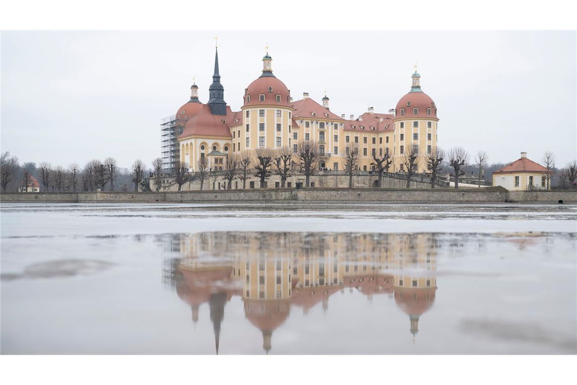 Bilder des Tages Schloss gespiegelt: Das Schloss Moritzburg in Sachsen spiegelt sich im Tauwassser auf in einer Eisfläche auf dem Schlossteich.