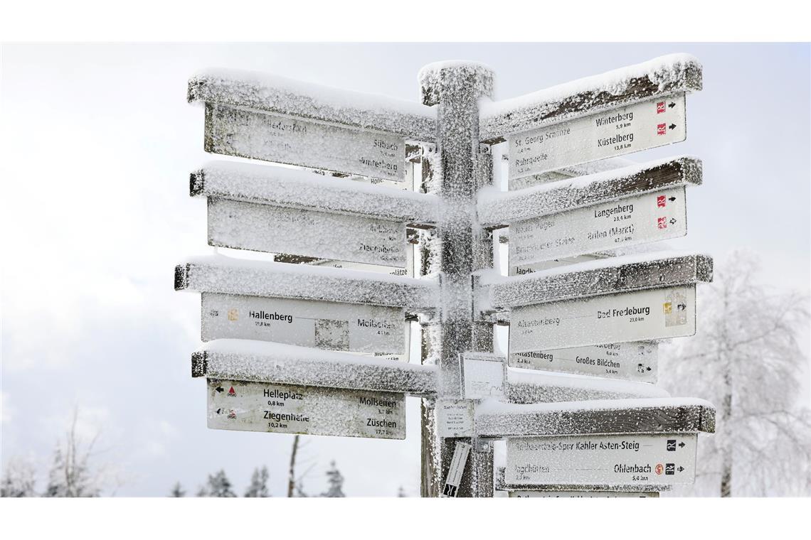 Schnee liegt auf Wegweisern am Kahlen Asten im Sauerland.
