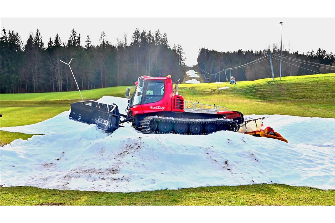 Schneereste mit einer Pistenraupe am Skihang, warten im oberbayerischen Siegsdorf auf den richtigen Winter (Archivbild).