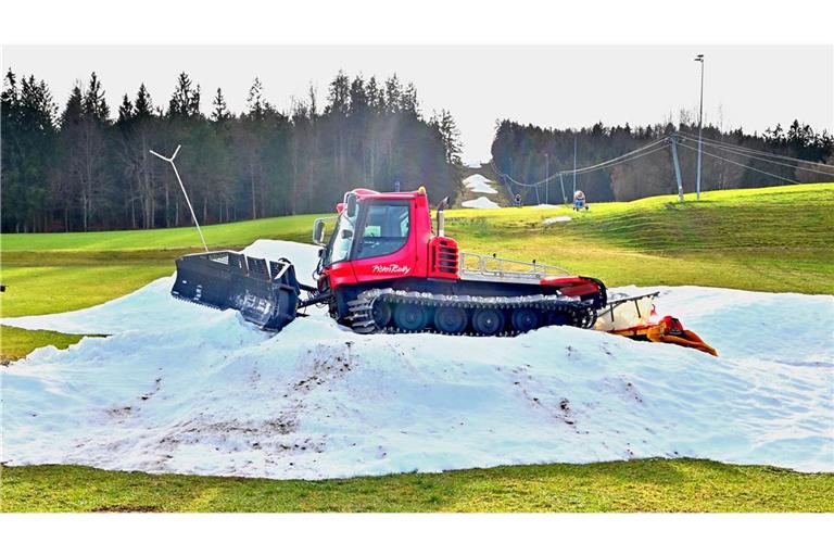 Schneereste mit einer Pistenraupe am Skihang, warten im oberbayerischen Siegsdorf auf den richtigen Winter (Archivbild).