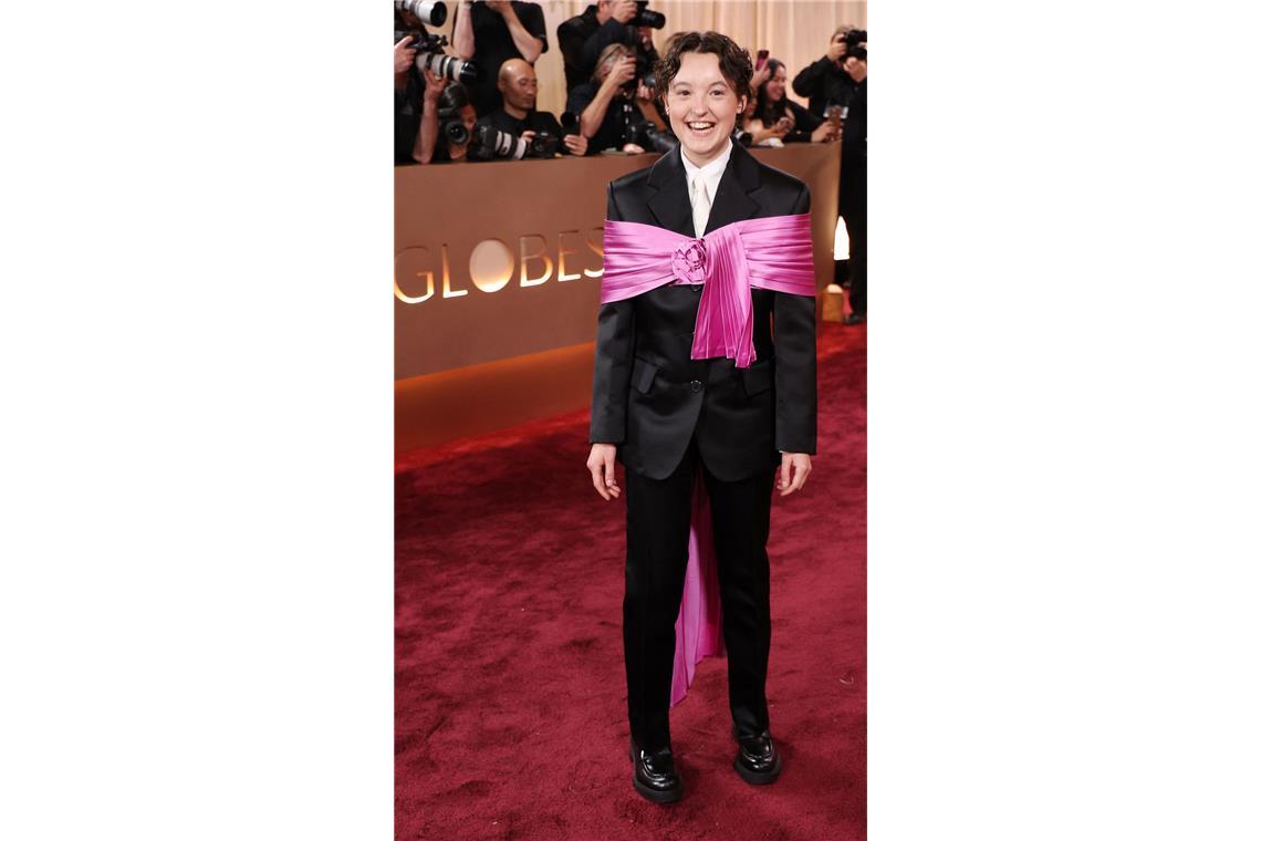 Schön, auch bei eingeschränkter Bewegungsfreiheit: Bella Ramsey ein einem schwarzen Satinanzug von Prada mit signalpinker Stola.