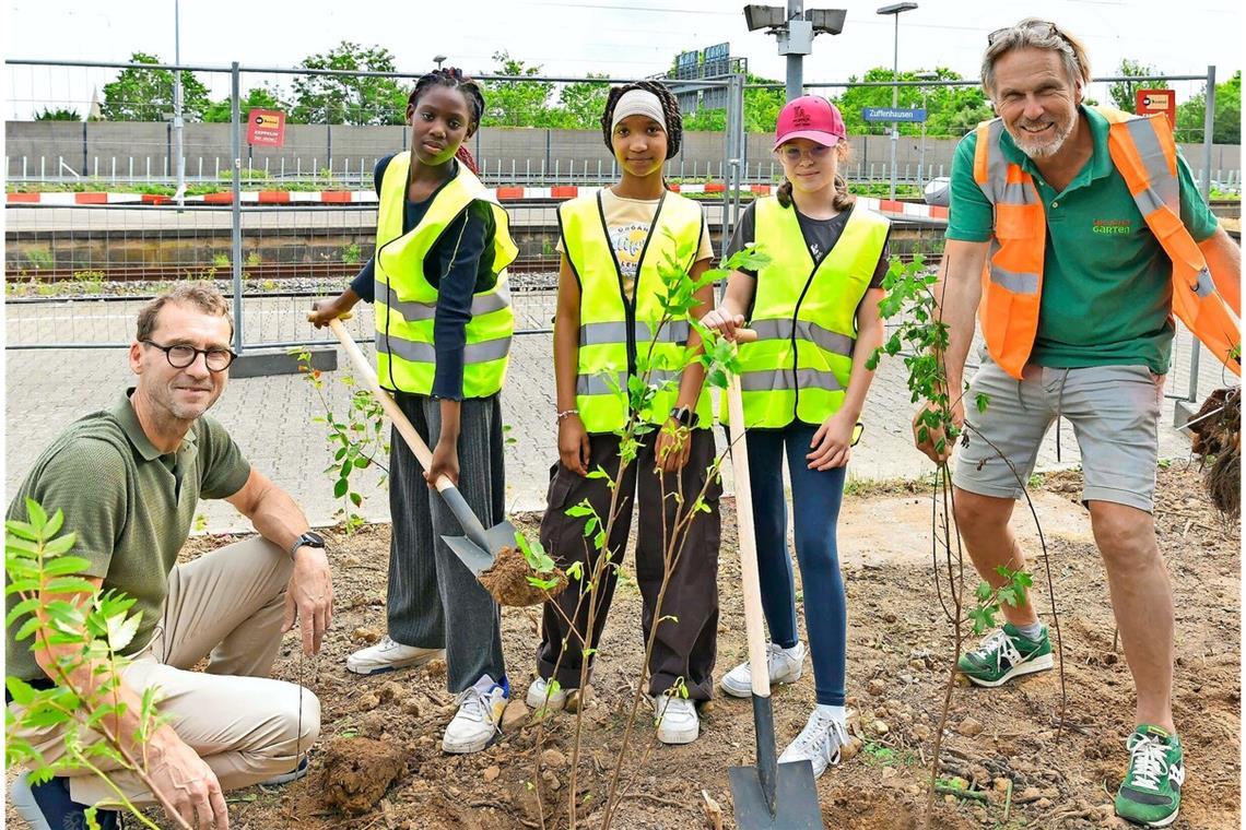 Schülerinnen der Bertha-von-Suttner-Schule beim Spatenstich für den „Tiny Forest“ am Bahnhof in Zuffenhausen. Nikolaus Hebding (li.) von der Deutschen Bahn und Michael Kupka von „The Tiny Group“ betreuen das Projekt.