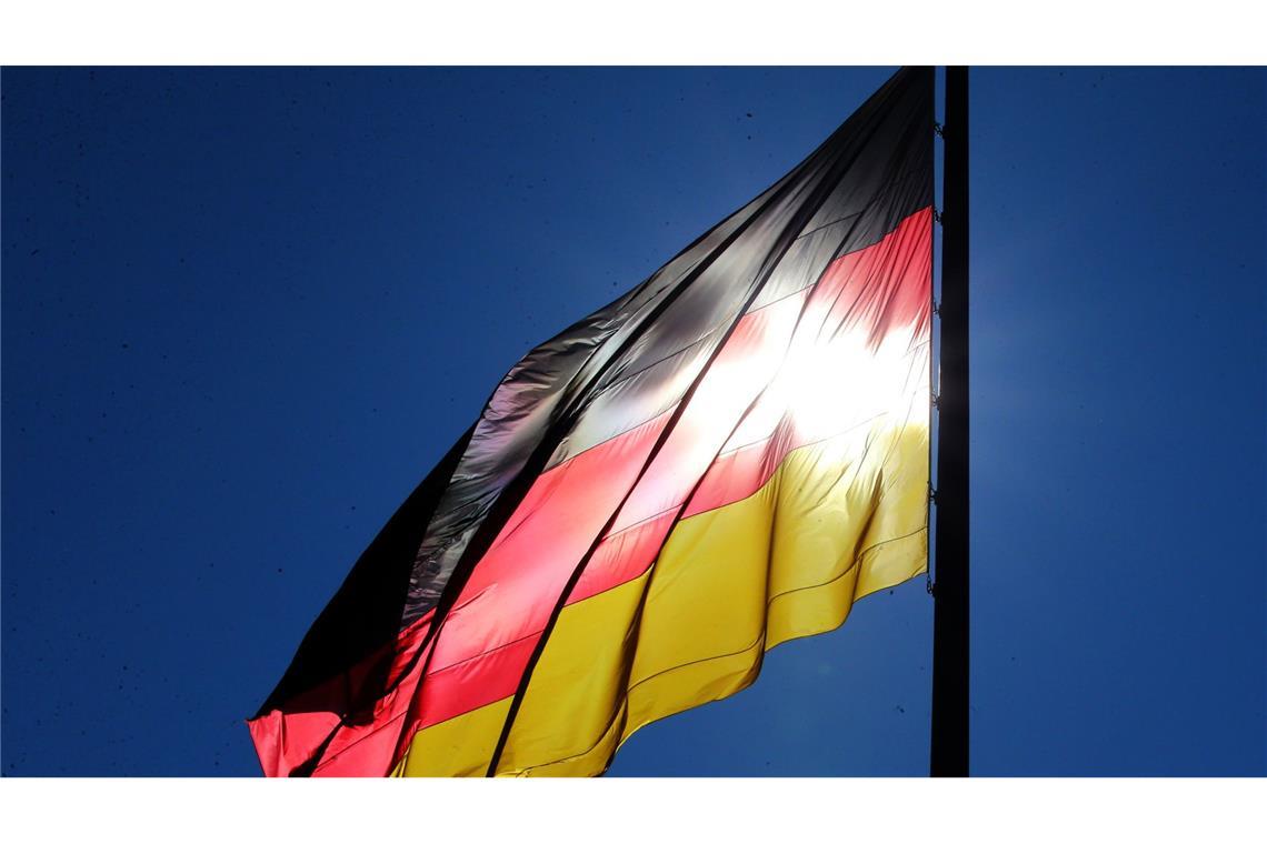 Was ist eine Deutschland-Koalition? Schwarz-rot-gold vor blauem Hintergrund: Eine starkes Abschneiden der AfD könnte dazu führen, dass nach der Bundestagswahl eine Dreier-Koalition entsteht.