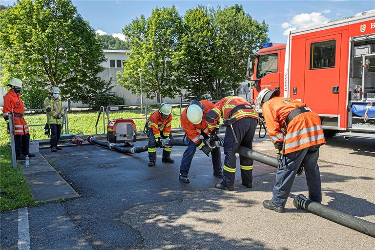 Schweres Geschäft: Dieses Quartett ist gerade dabei, eine Wasserversorgung aus der Murr aufzubauen, die am Murrhardter Feuerwehrhaus vorbeifließt. Fotos: J. Fiedler