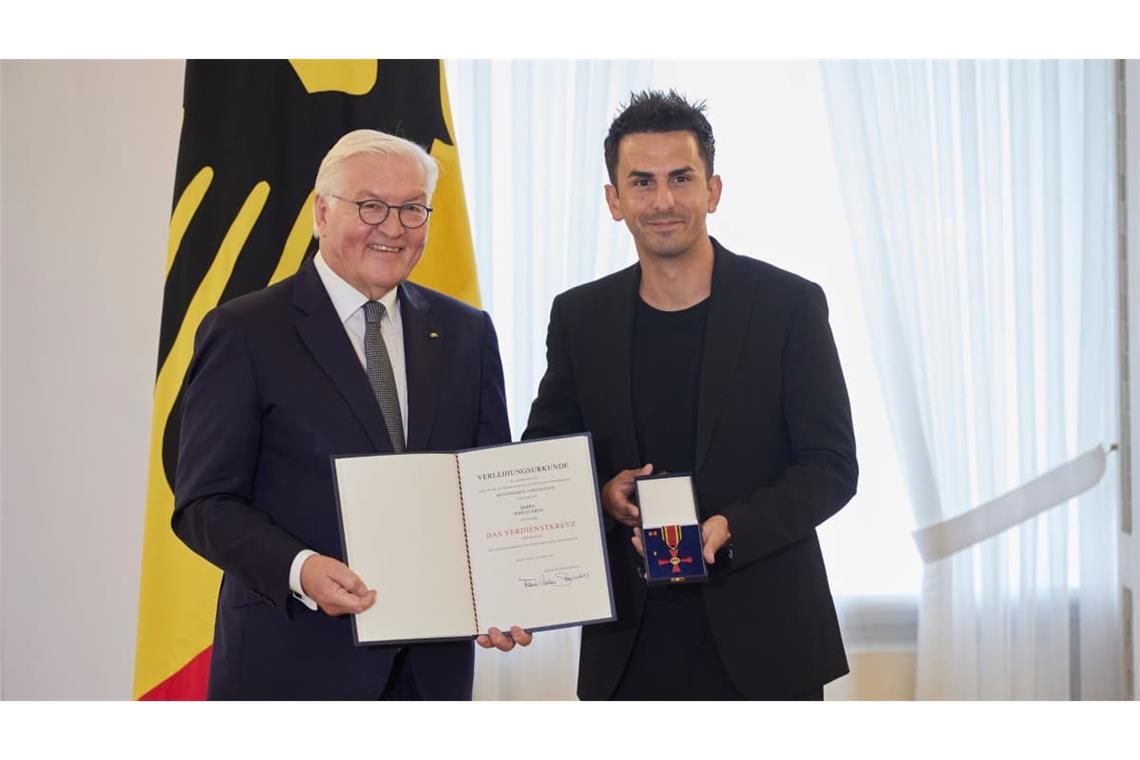 Serkan Eren (rechts) 2023 mit Bundespräsident Frank-Walter Steinmeier: damals mit dem Bundesverdienstkreuz ausgezeichnet, heute zu zehn Jahren Haft im Iran verurteilt. Das Auswärtige Amt fühlt sich
