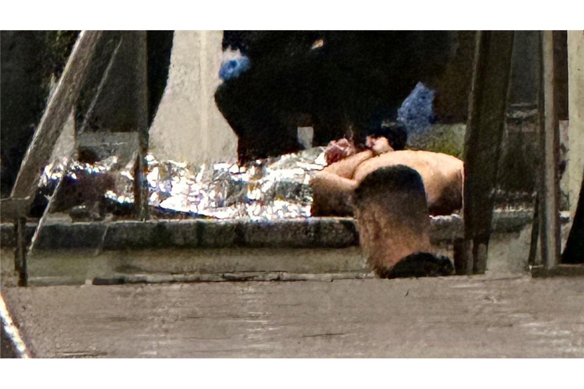 Sicherheitskräfte umringten eine am Boden liegende Person.