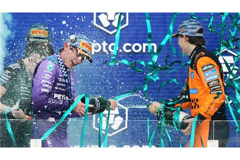 Sieger Mercedes-Pilot Kimi Antonelli (l) aus Italien feiert mit dem drittplatzierten McLaren-Fahrer Oscar Piastri aus Australien auf dem Podium nach dem Großen Preis von Miami.