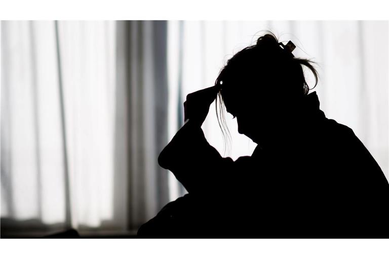 Silhouette einer Frau vor einer hellen Fensterfront