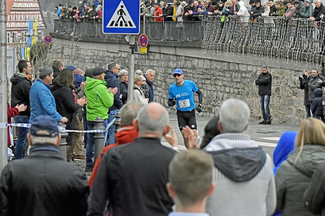 Ein Finisherrekord und zwei Favoritensiege beim 36. Backnanger Silvesterlauf Silvesterlaufsieger Jens Mergenthaler zieht von allen Seiten die Blicke der vielen Zuschauer auf sich. Foto: Tobias Sellmaier