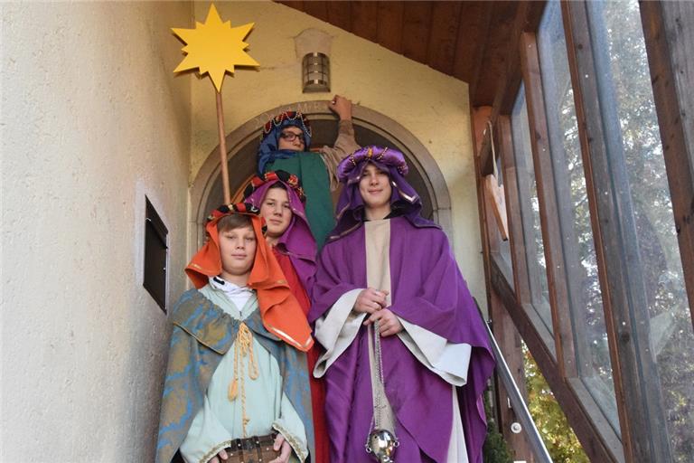 Sind seit Jahren fleißige Sternsinger (von links): „Melchior“ Johannes Tritschler, Sternträger Vincent Tritschler, „Balthasar“ Felix Schulte, der gerade den Segensspruch auf den Türbogen schreibt, und „Kaspar“ Paul Tritschler. Foto: Elisabeth Klaper