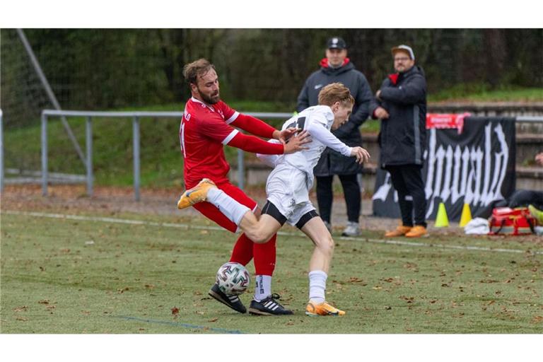 So sieht Abstiegskampf aus: Aichwalds Fabian Müller (links) packt zu, Luka Exner vom VfBOEZ kämpft mit dem Gleichgewicht. Und ASV-Coach Jan Singer (hinten rechts) beobachtet das Ganze wohlwollend.