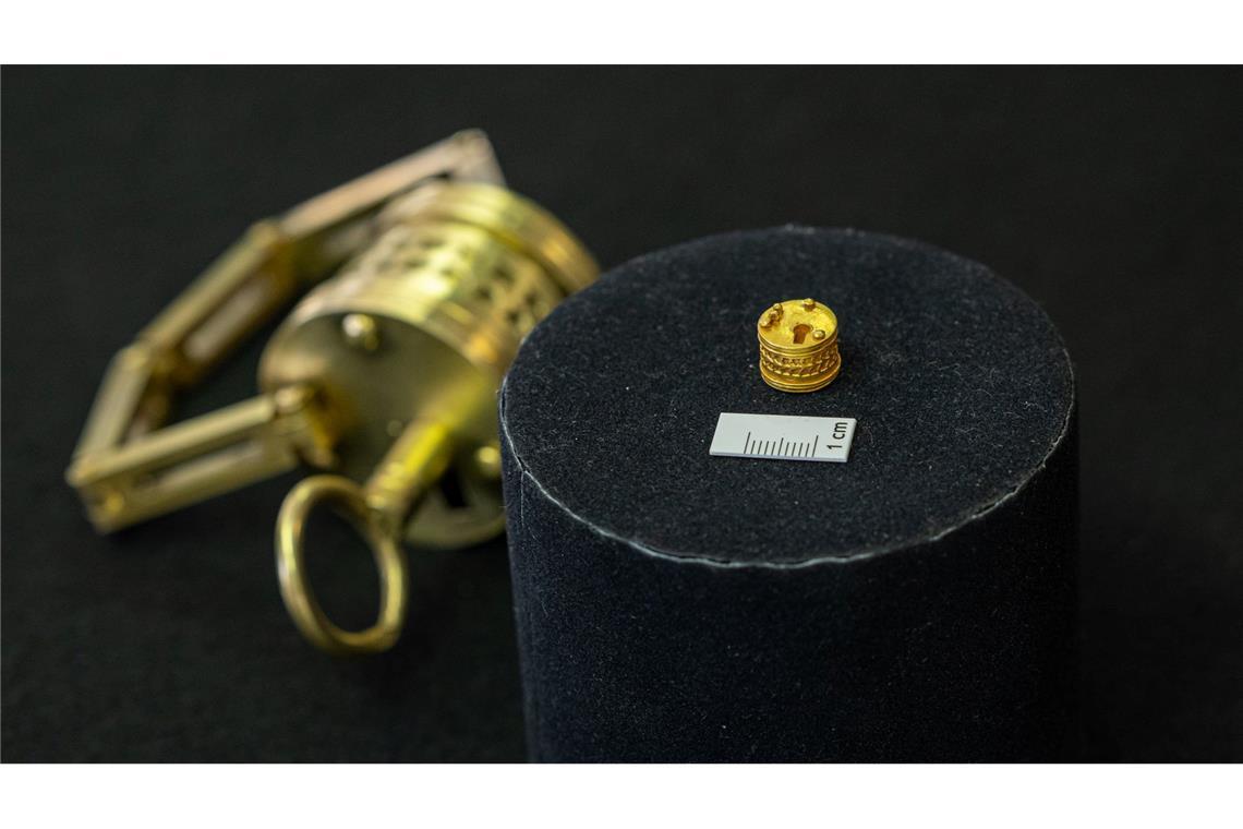 Römisches Mini-Dosenschloss aus Gold gibt Rätsel auf So winzig: Das römische Miniatur-Schloss liegt neben einem Maßstab für einen Zentimeter. Im Hintergrund der Nachbau im Verhältnis 4:1.