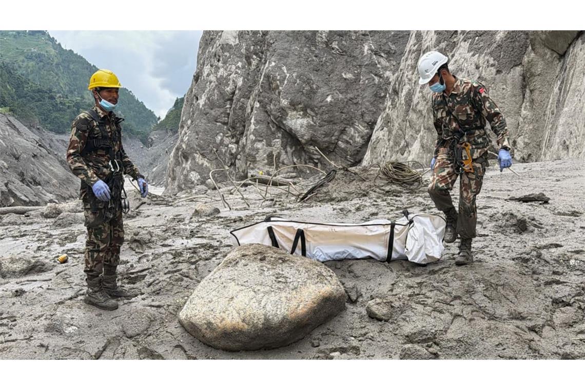 Soldaten der nepalesischen Armee tragen die Leiche eines Arbeiters, die an der Baustelle eines Wasserkraftprojekts in Upper Trishuli, Nepal, geborgen wurde.