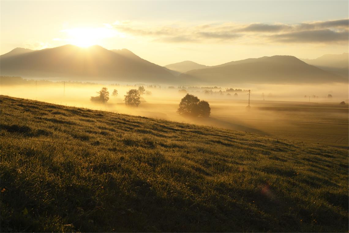 Wann geht die Sonne heute auf und unter? Sonnenaufgang hinter den Bergen.