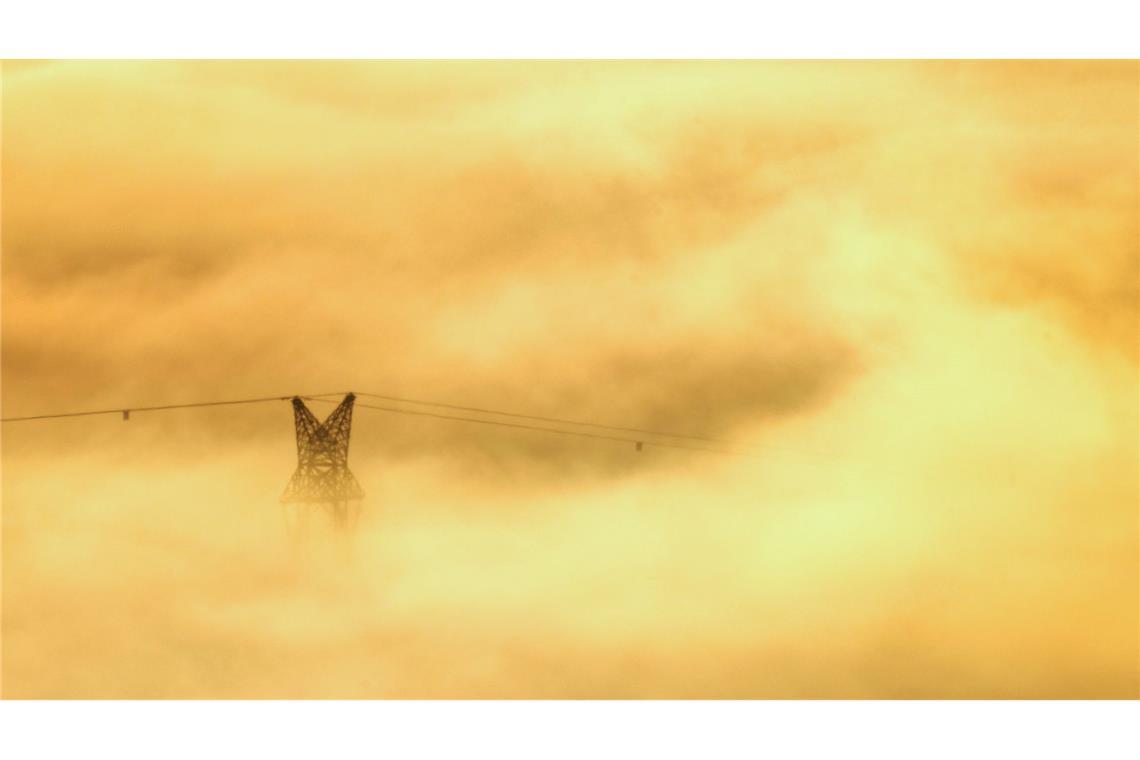 Sonnenaufgang in Riedlingen: Strommastspitze im goldenen Nebel