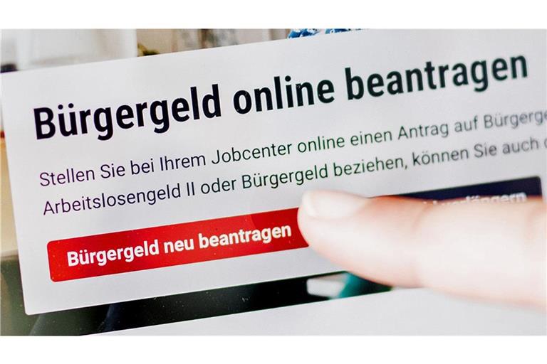 Sozialstaat – teuer, ineffizient, unbezahlbar? Eine Frau tippt auf einem Tablet auf einen Link zum Beantragen des Bürgergeldes im Kundenbereich im Jobcenter Berlin-Mitte.