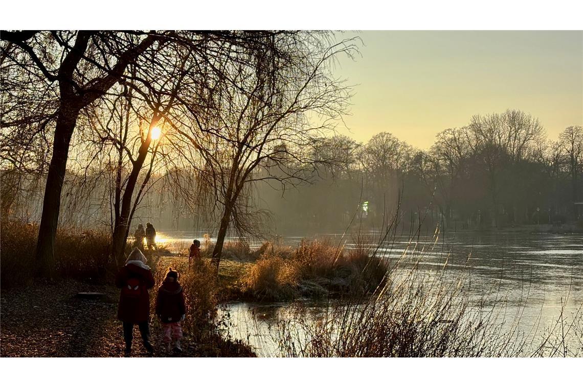 Spaziergänger sind am zugefrorenen Schloßteich in Chemnitz unterwegs.
