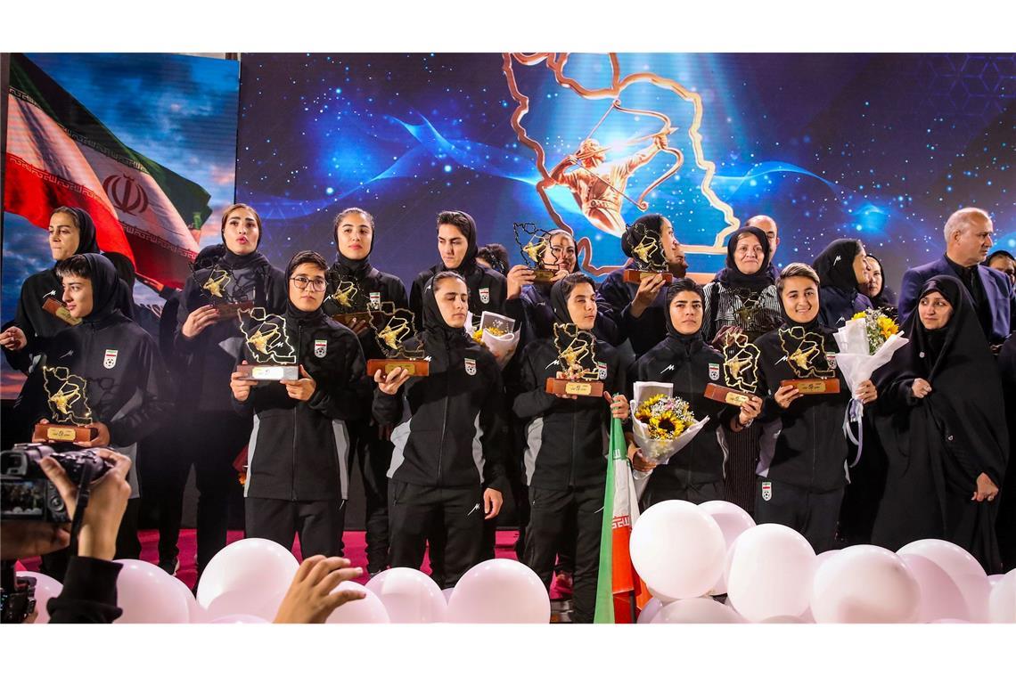 Spielerinnen der iranischen Fußball-Nationalmannschaft stehen auf einer Bühne in Teheran, während einer Empfangszeremonie nach ihrer Teilnahme am AFC Women's Asian Cup in Australien.