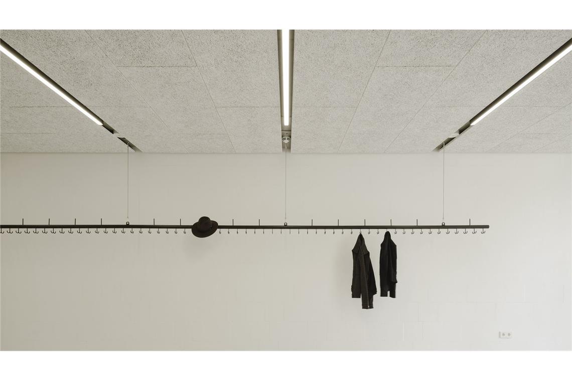 Stilvoll bis ins Detail: Die vom Büro Atelier Kaiser Shen selbst entworfene Garderobenstange, die im Eingangsbereich von der Decke hängt, könnte auch bei einer Ausstellung fürs Bilderaufhängen verwendet werden.