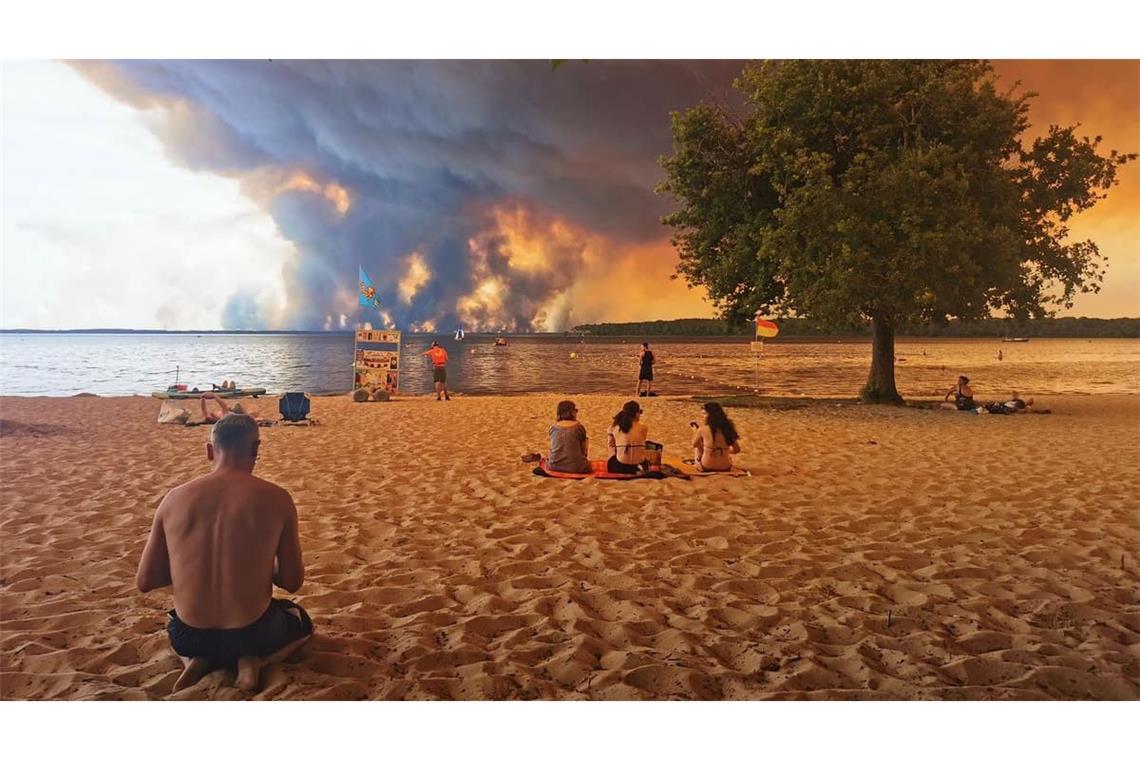 Strandbesucher sitzen im Juli 2026 am Strand von Moutchic in Lacanau im Südwesten Frankreichs, während Rauchwolken von einem Waldbrand in den Himmel aufsteigen. 