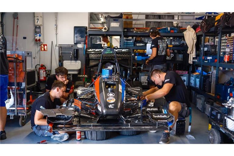 Studenten an einem Rennwagen beim Konstruktionswettbewerb Formula Student Germany am Hockenheimring. Für Unternehmen ist das Event auch ein Recruitingpool, weil sie mit den Ingenieuren von morgen in Kontakt kommen.