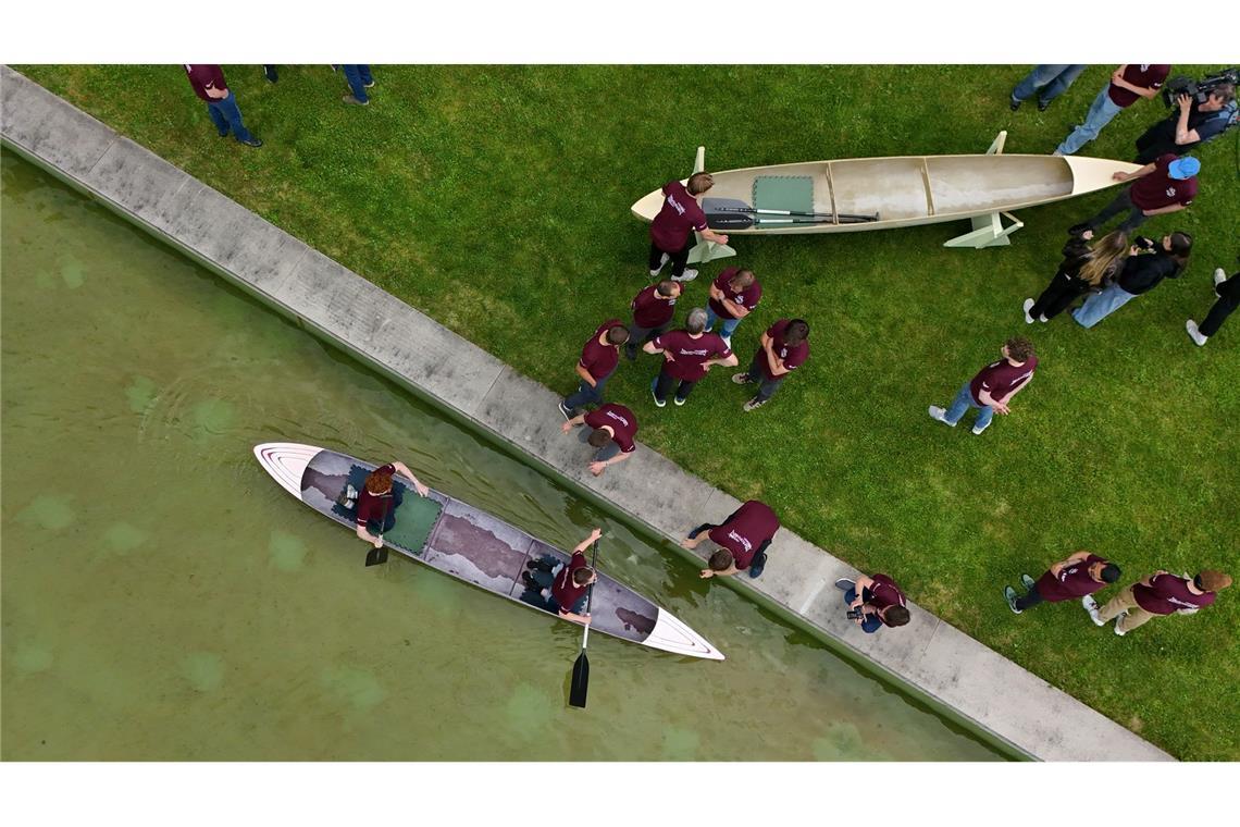 Studenten und Studentinnen der Bauhaus-Universität Weimar fahren mit dem Betonkanu auf dem Wasser im Weimarer Schwanseebad. (Aufnahme mit einer Drohne)