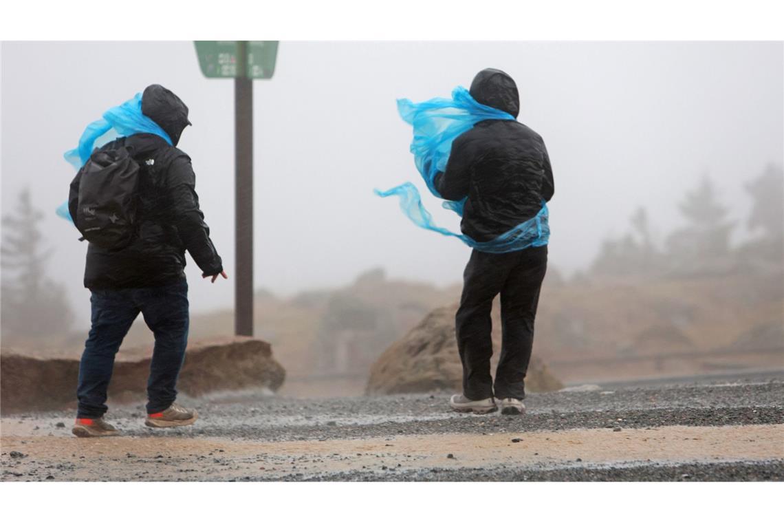 Bilder des Tages Sturmtief "Joshua" - Sachsen-Anhalt: Wanderer gehen am Nachmittag auf dem Brocken entlang.