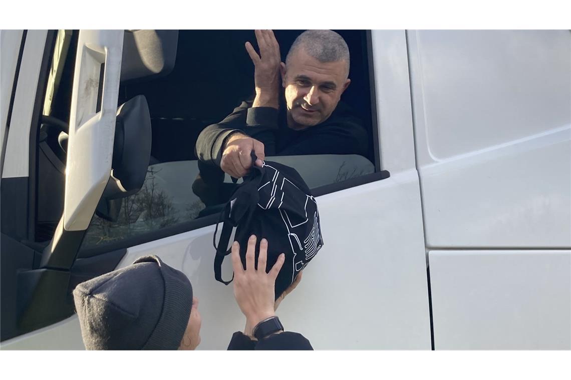 Überraschung am Rastplatz – Daimler Truck beschenkt Lkw-Fahrer Süßigkeiten, Obst und eine Wollmütze: Daimler-Truck-Mitarbeiter verteilen Geschenke auf dem Rastplatz.