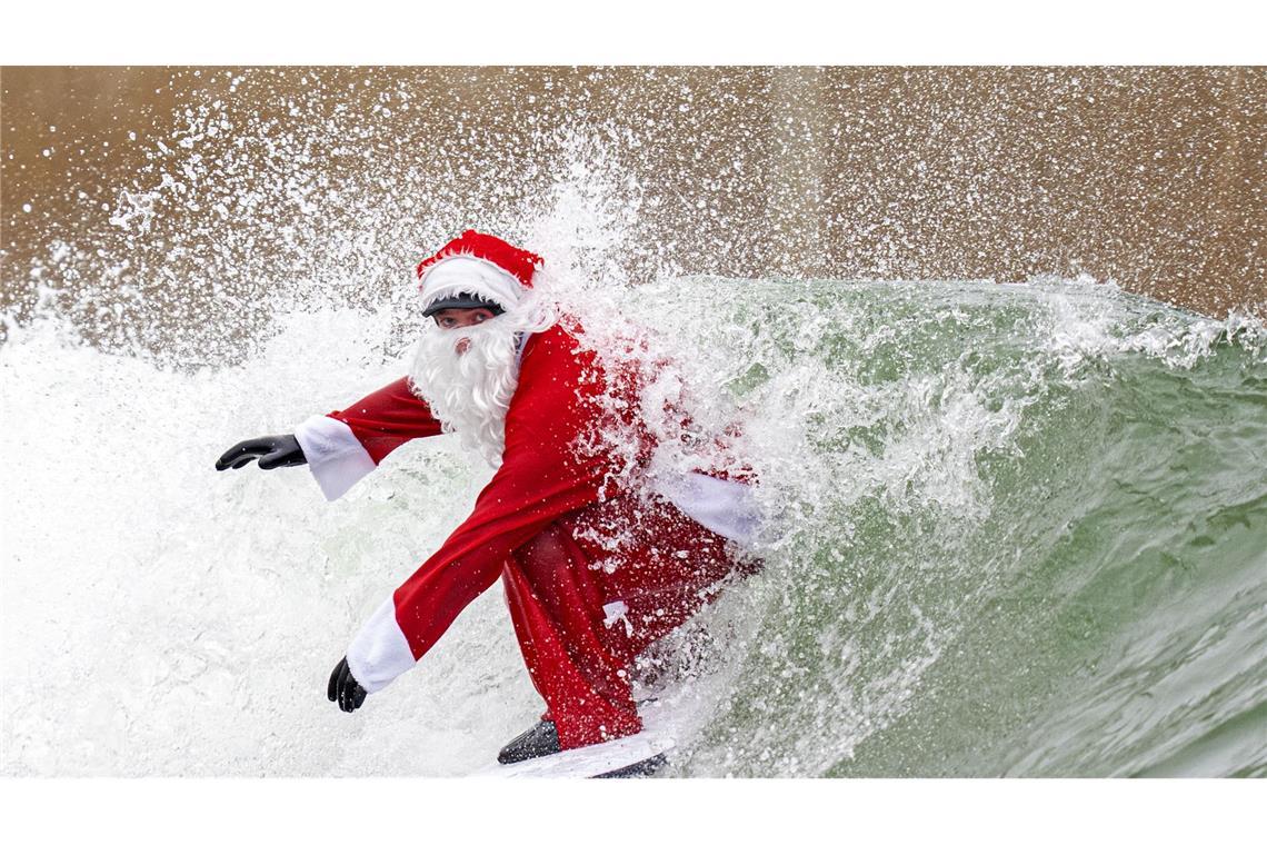 Surflehrer und Rettungsschwimmer Finn Clark aus Gorebridge verkleidet sich als Weihnachtsmann für eine Surfsession im Lost Shore Surf Resort in Newbridge, in der Nähe von Edinburgh.