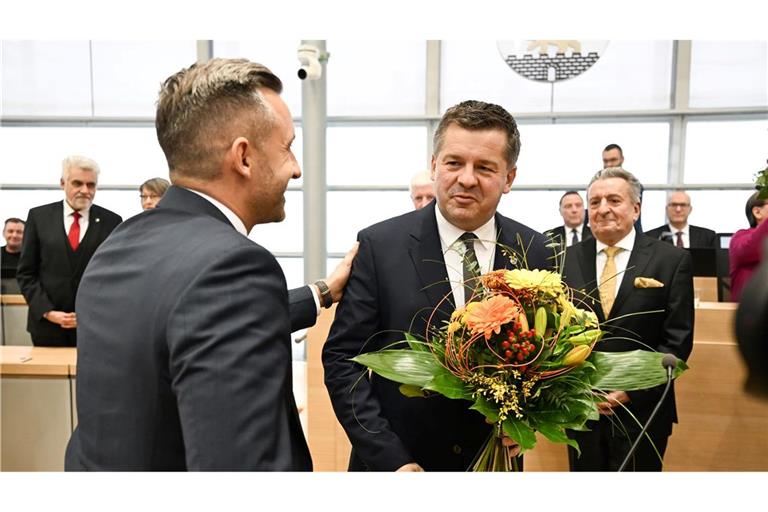 Sven Schulze bekommt Glückwünsche und einen Blumenstrauß vom AfD-Spitzenkandidaten Ulrich Siegmund.